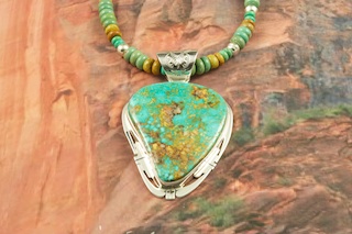Genuine High Grade Kingman Web Turquoise set in Sterling Silver. Stunning Pendant and Necklace Set. The Turquoise Necklace features Turquoise and Jasper Rondelle beads with Sterling Silver Beads and Clasp. The Mineral Park Mine, in the Cerbat Mountains 14 miles northwest of Kingman, was first mined by Indians centuries before white man came to the area. It is one of the three sites of prehistoric mining localities in the state of Arizona. Mineral Park was the most extensively worked area by the Indians of the three. S.A. �Chuck� Colbaugh found a cache of stone hammers uncovered in ancient trenches and tunnels, when he had the turquoise mining concession in May of 1962. Ithaca Peak and Turquoise Mine (formally called Aztec Mountain or Aztec Peak) are the most famous of the peaks in the area containing turquoise. The photo is of the jewelry you will be receiving. Created by Navajo Artist Phillip Sanchez. Signed by the artist.
